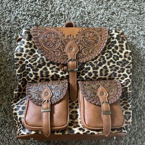 BRAND NEW! Montana west bag. Includes floral tooling on pocket flaps.